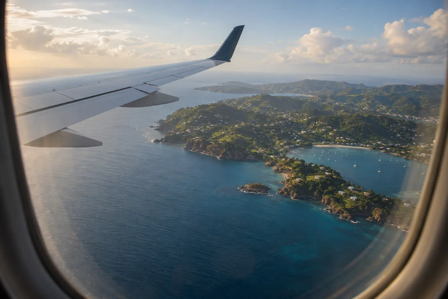 Grenada passport journeys across the Caribbean Aircraft wing over the Caribbean at the end of the day